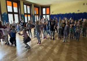Na zdjęciu dzieci na sali gimnastycznej bawiące się przy wesołej muzce.