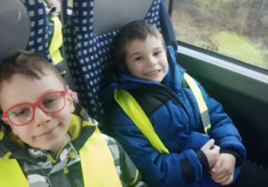 Na zdjęciu dwóch chłopców na fotelach w autokarze w drodze do kina.