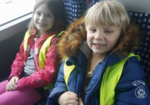 Na zdjęciu chłopiec i dziewczynka na fotelach w autokarze w drodze do kina.
