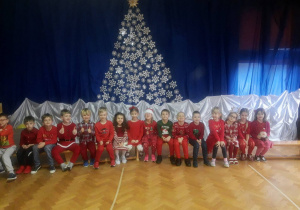 Dzieci przedszkolne ubrane w kolory czerwieni pozują do zdjęcia grupowego.