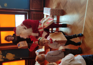 Mikołaj rozdaje prezenty dzieciom