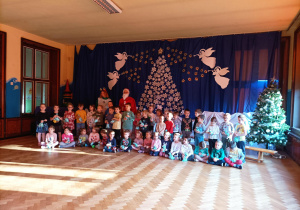 Wspólne zdjęcie wszystkich dzieci z Mikołajem oraz jego pomocnikami
