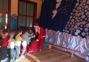 Dzieci dostają od Świętego Mikołaja i elfów prezenty