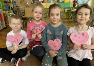 Na zdjęciu 4 dzieci trzyma własnoręcznie robione walentynki w kształcie serduszek