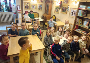 Na zdjęciu dzieci siedzące przy stolikach oczekują na spektakl.