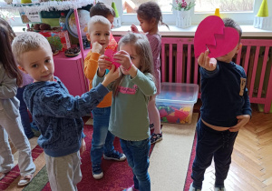 Na zdjęciu dzieci trzymają połączone połówki serca.