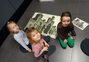 Na zdjęciu dzieci układają puzzle prezentujące ,,Centrum Włókiennictwa''
