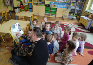 tata Kai wraz z dziećmi podczas czytania książki
