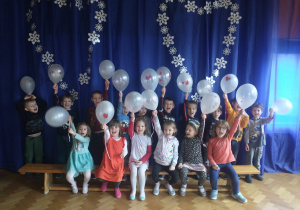 Grupa Zajączki z balonami na tle dekoracji.