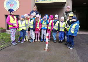 dzieci wraz z nauczycielka stoją przed wejściem do "Baśniowej kawiarenki"