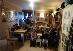 dzieci siedzą przy stolikach w Baśniowej Kawiarence czekając na przedstawienie