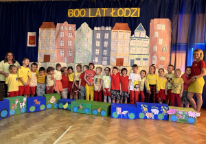 Grupa piąta wraz z nauczycielkami pozuje na tle dekoracji z okazji 600 lat miasta Łodzi