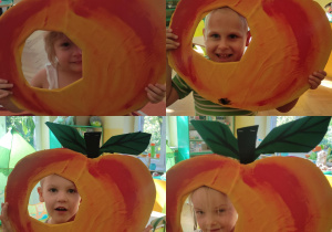 dzieci pozujące do zdjęcia z makietą przedstawiającą jabłko