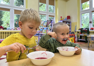 Na zdjęciu dwóch chłopców podczas jedzenia obiadu.