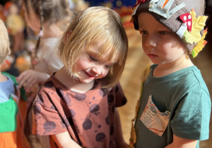 Na zdjęciu dwoje dzieci w przebraniach tańczy w parze na sali.
