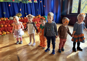 Na zdjęciu dzieci w jesiennych przebraniach na sali gimnastycznej.