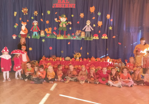 Wspólne zdjęcie dzieci z grupy Skrzaty na tle dekoracji "Bal Jesieni''