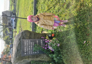 Dziewczynka stoi przy miejscu pamięci Czterech Partyzantów którzy zginęli z rąk Hitlerowców.