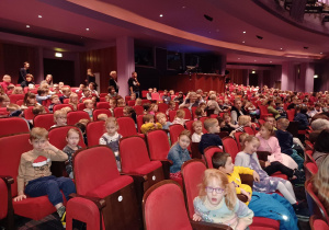 na zdjęciu dzieci siedzące na widowni teatru