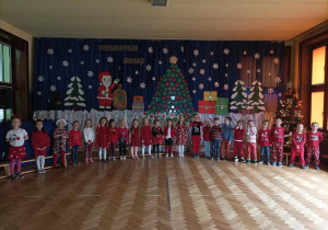 Grupowe zdjęcie dzieci z grupy Skrzaty na tle dekoracji świątecznej.