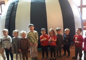 Zdjęcie przedstawia dzieci z grupy "Misie" stojące przed kopułą kina sferycznego