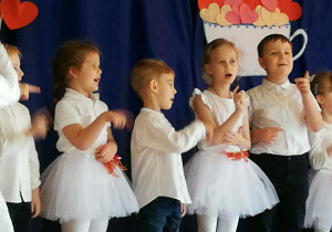 Dzieci ubrane odświętnie podczas śpiewania piosenki.