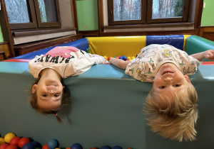 Na zdjęciu dwoje dzieci podczas zabaw w basenie z kolorowymi piłeczkami.