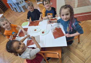 Dzieci malują karton farb na brązowo.