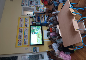 ​dzieci oglądają na tablicy multimedialnej film " Skąd się bierze żywność ekologiczna?"