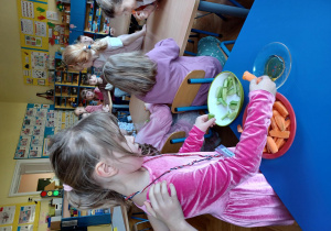 dzieci smakują ekologiczna marchewkę i ogórka z ekologicznym miodem