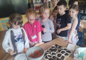 Dzieci podczas nakładania na talerze surówki.
