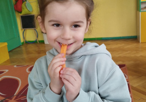 Dziewczynka zjadająca marchewkę